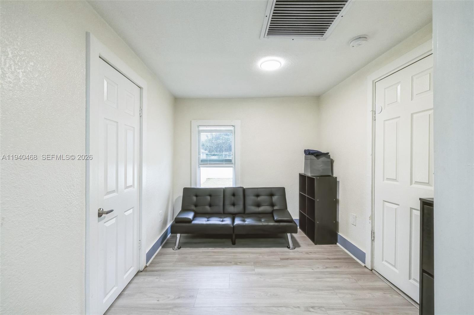 1296 Northwest 72nd Street Miami, FL 33147 - Photo 10 of 12 a living room with a bed furniture and a window
