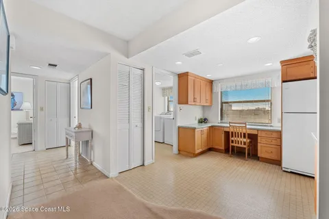 a kitchen with a refrigerator a stove and a sink with wooden floor