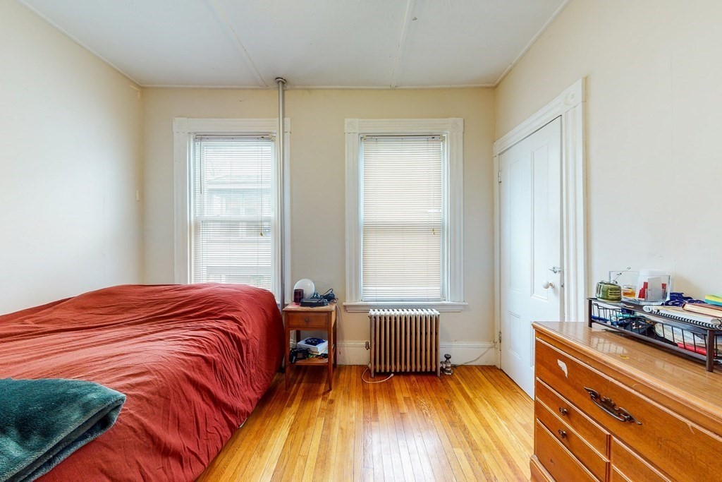 26 Clark Street Somerville, MA 02143 - Photo 6 of 32 a bed sitting in a bedroom next to a window