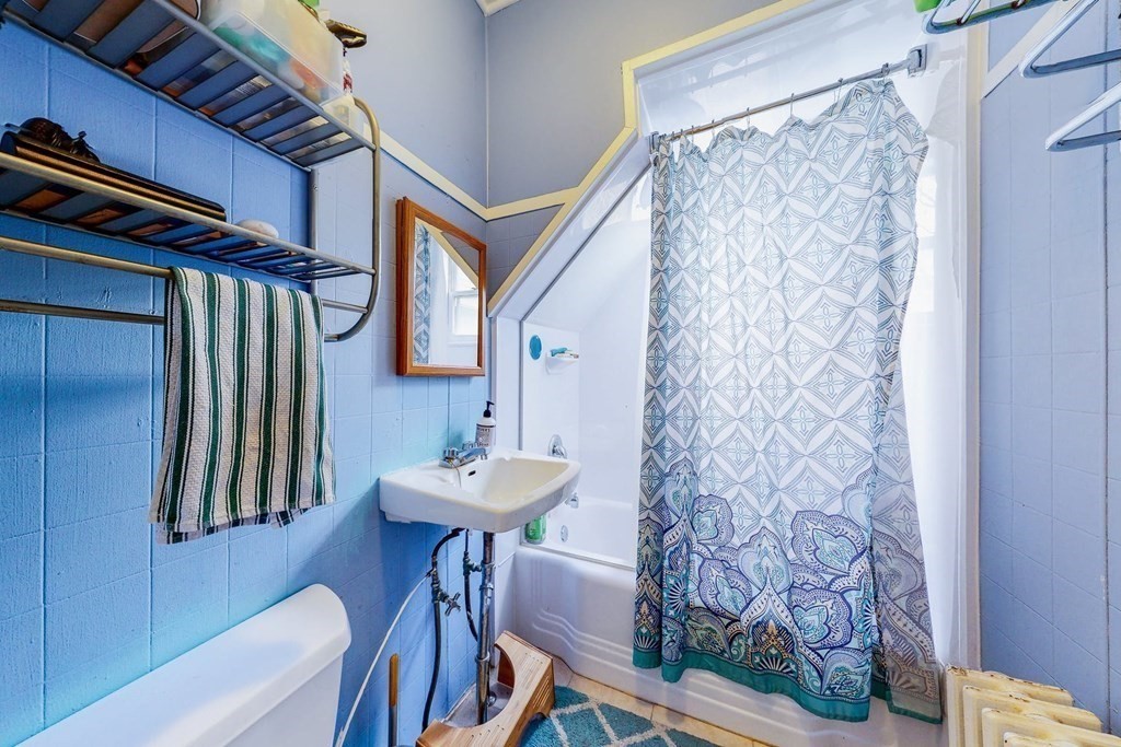 26 Clark Street Somerville, MA 02143 - Photo 9 of 32 a bathroom with a sink a mirror and a shower curtain