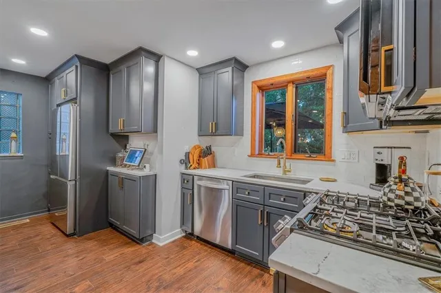 a kitchen with stainless steel appliances granite countertop a stove a sink and a refrigerator