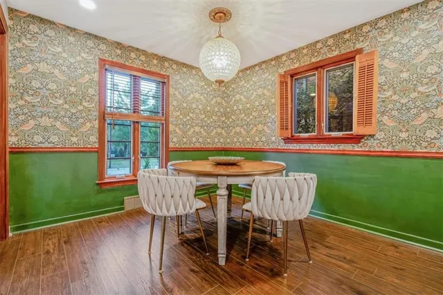 a dining room with furniture a chandelier and wooden floor