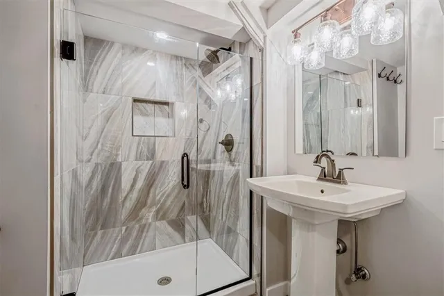 a bathroom with a sink a mirror a bathtub and shower
