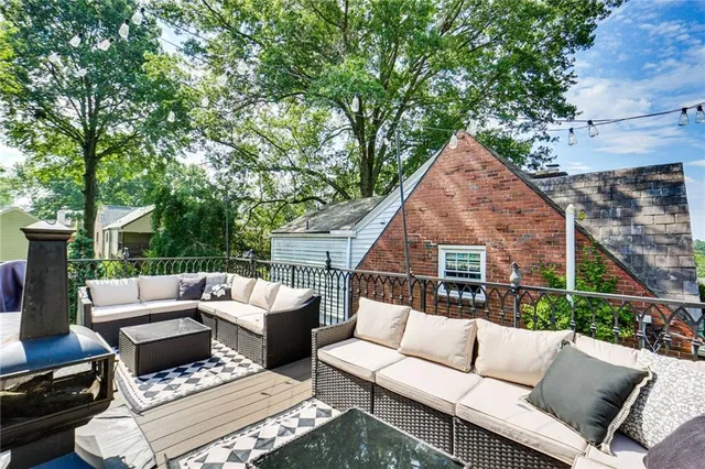 a view of a patio with couches table and chairs with wooden fence and floor