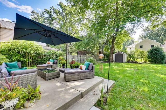 a view of a patio with couches and table and chairs under an umbrella