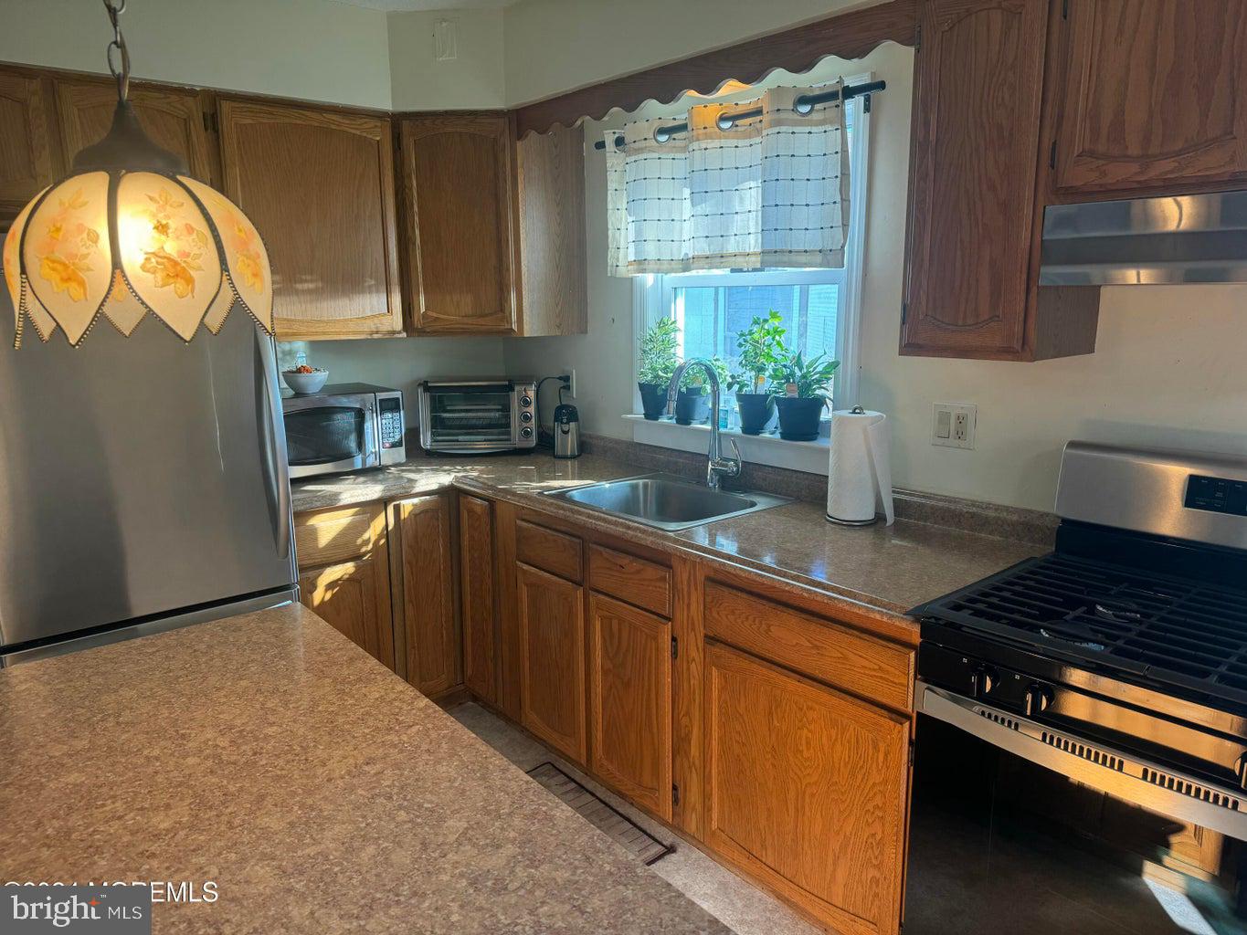 16 Mandalay Road Brick, NJ 08723 - Photo 7 of 22 a kitchen with stainless steel appliances granite countertop a stove a sink and a microwave