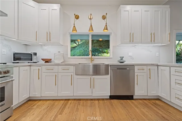 a kitchen with white cabinets a sink and dishwasher