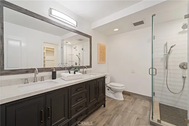 a bathroom with a double vanity sink toilet and shower