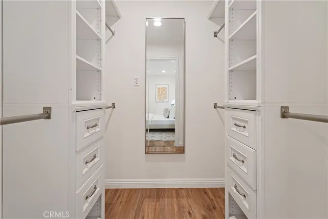 wooden floor with white cabinets and window