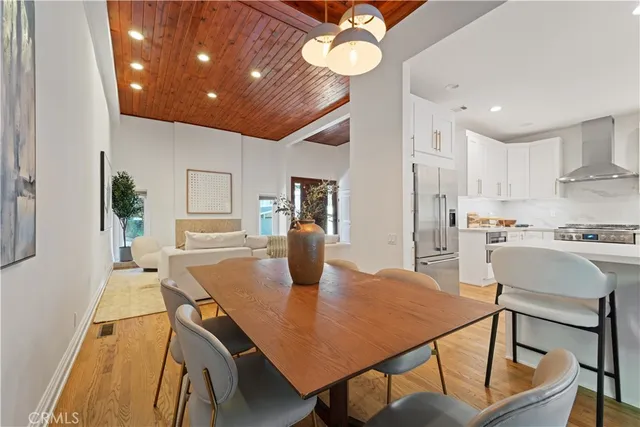 a kitchen with stainless steel appliances granite countertop a table chairs and a refrigerator