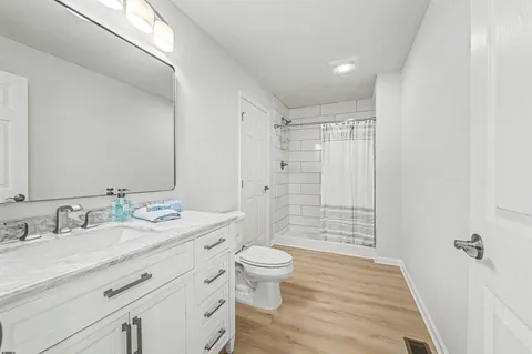 a bathroom with a double vanity sink toilet mirror and shower