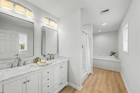a spacious bathroom with a granite countertop sink a toilet a mirror and shower