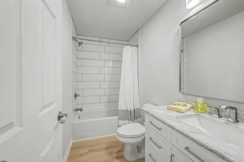 a bathroom with a granite countertop toilet a sink and bathtub