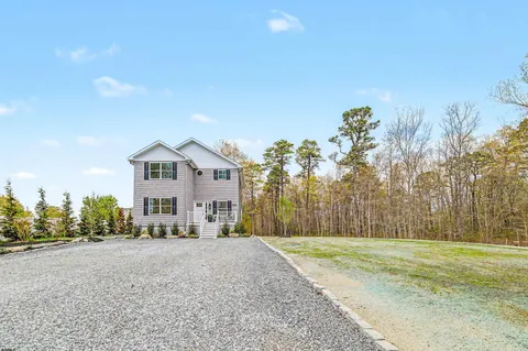 a front view of house with a yard and trees