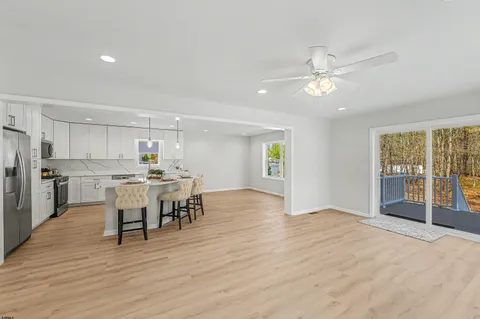a view of a kitchen with dining space wooden floor and appliances