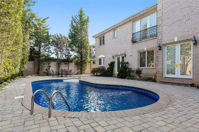 a view of a house with a swimming pool and sitting area