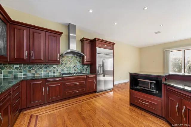 a large kitchen with stainless steel appliances granite countertop a refrigerator and a stove top oven