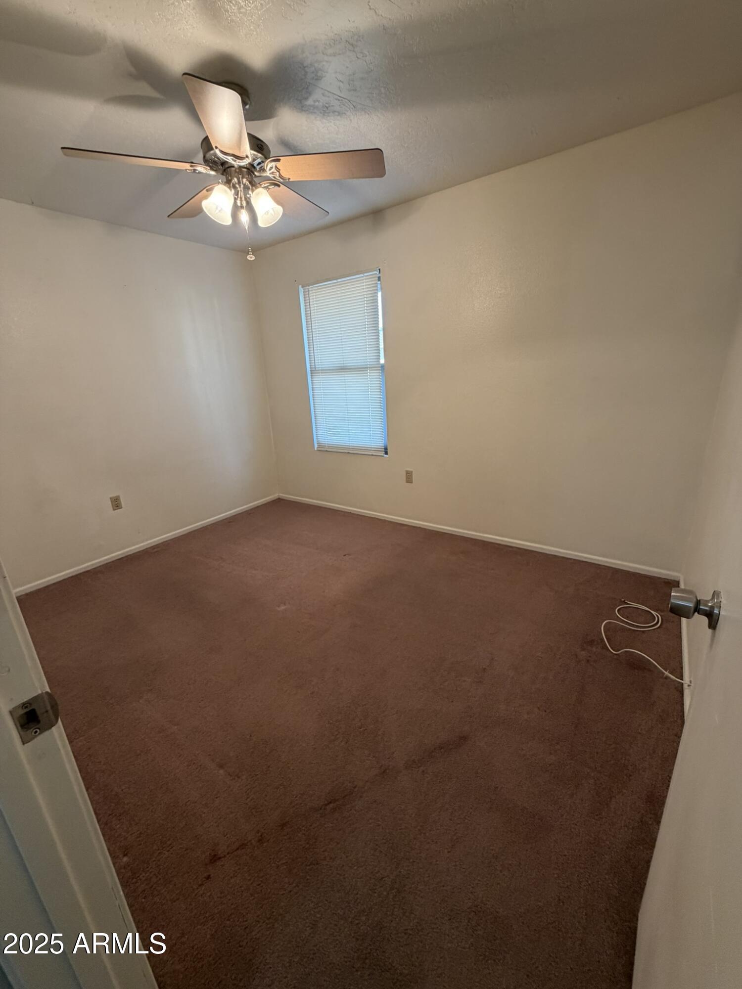463 North 64th Place, Unit 1 Mesa, AZ 85205 - Photo 9 of 19 en empty room with a fan and a chandelier fan