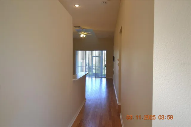 a view of a hallway with wooden floor