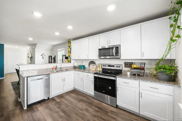a kitchen with granite countertop white cabinets and white appliances