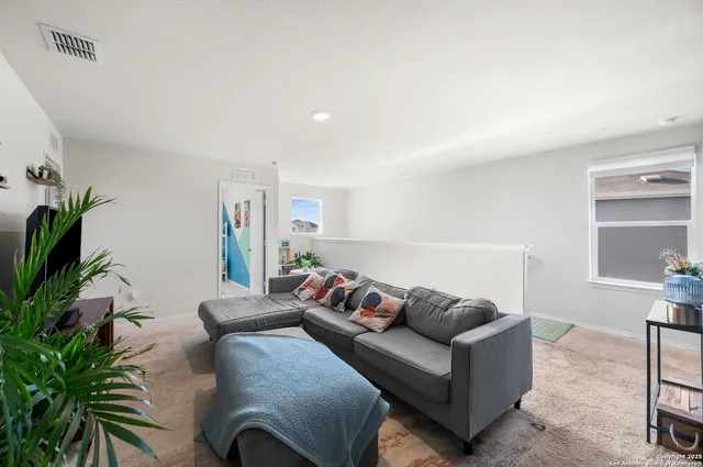 a living room with furniture and a potted plant