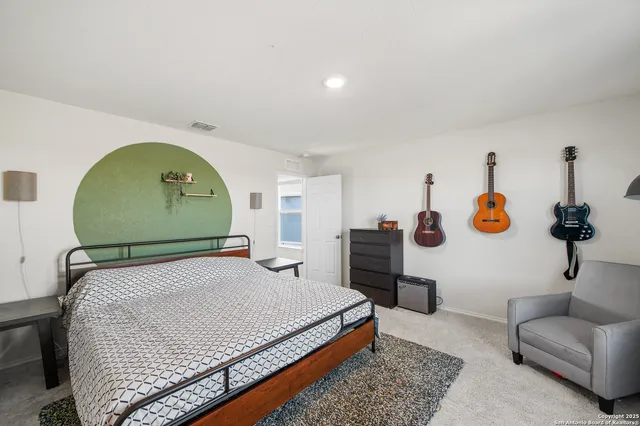 a bedroom with a bed a couch and dresser