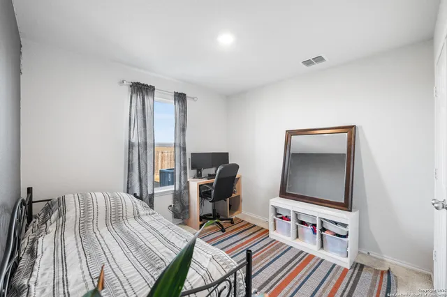 a bedroom with bed and a flat screen tv