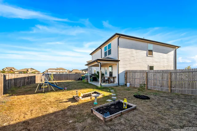 a view of a house with backyard and sitting area