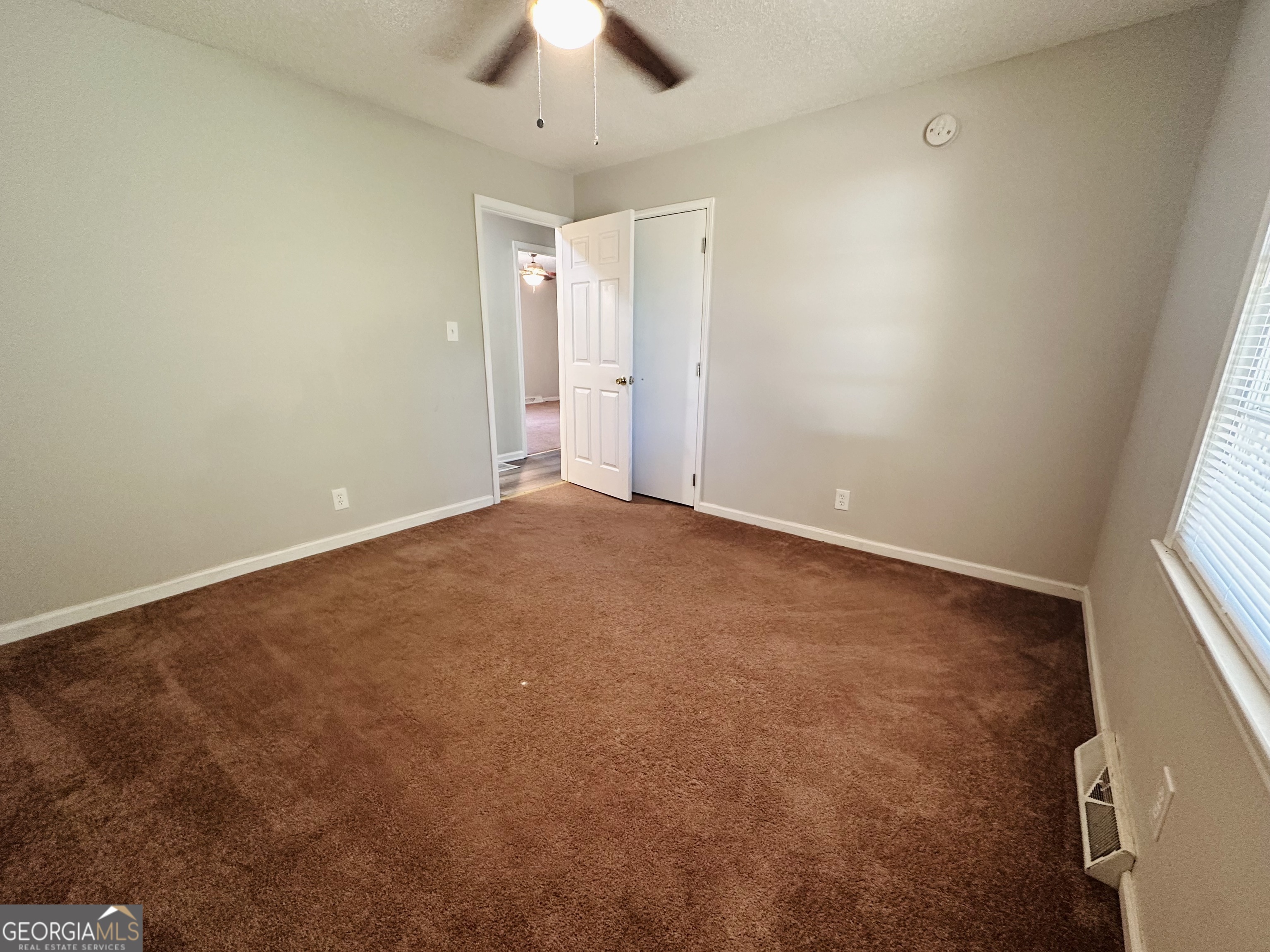 514 South Broad Street Toccoa, GA 30577 - Photo 13 of 22 an empty room with a chandelier fan and windows