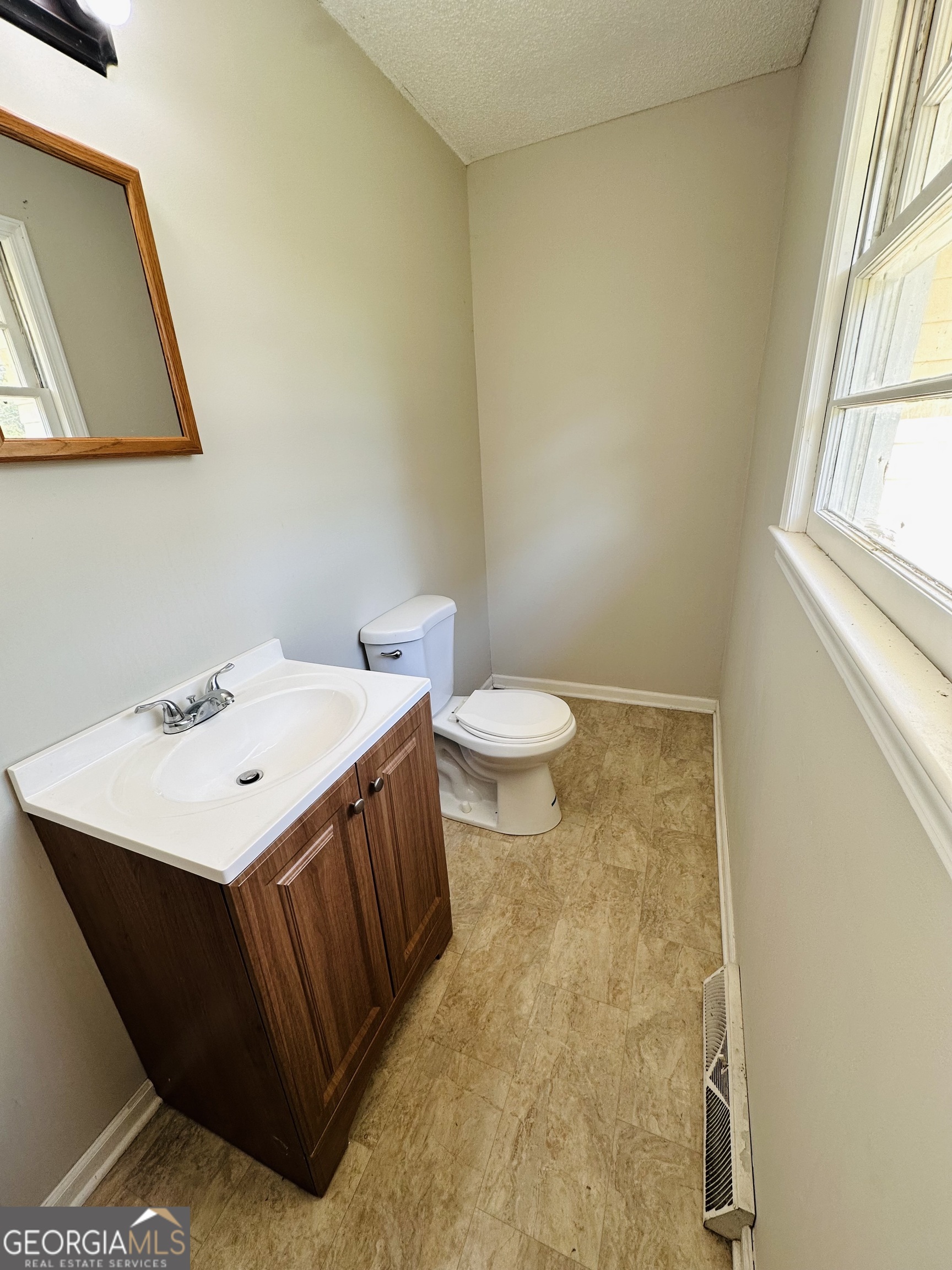 514 South Broad Street Toccoa, GA 30577 - Photo 16 of 22 a bathroom with a sink a toilet and mirror