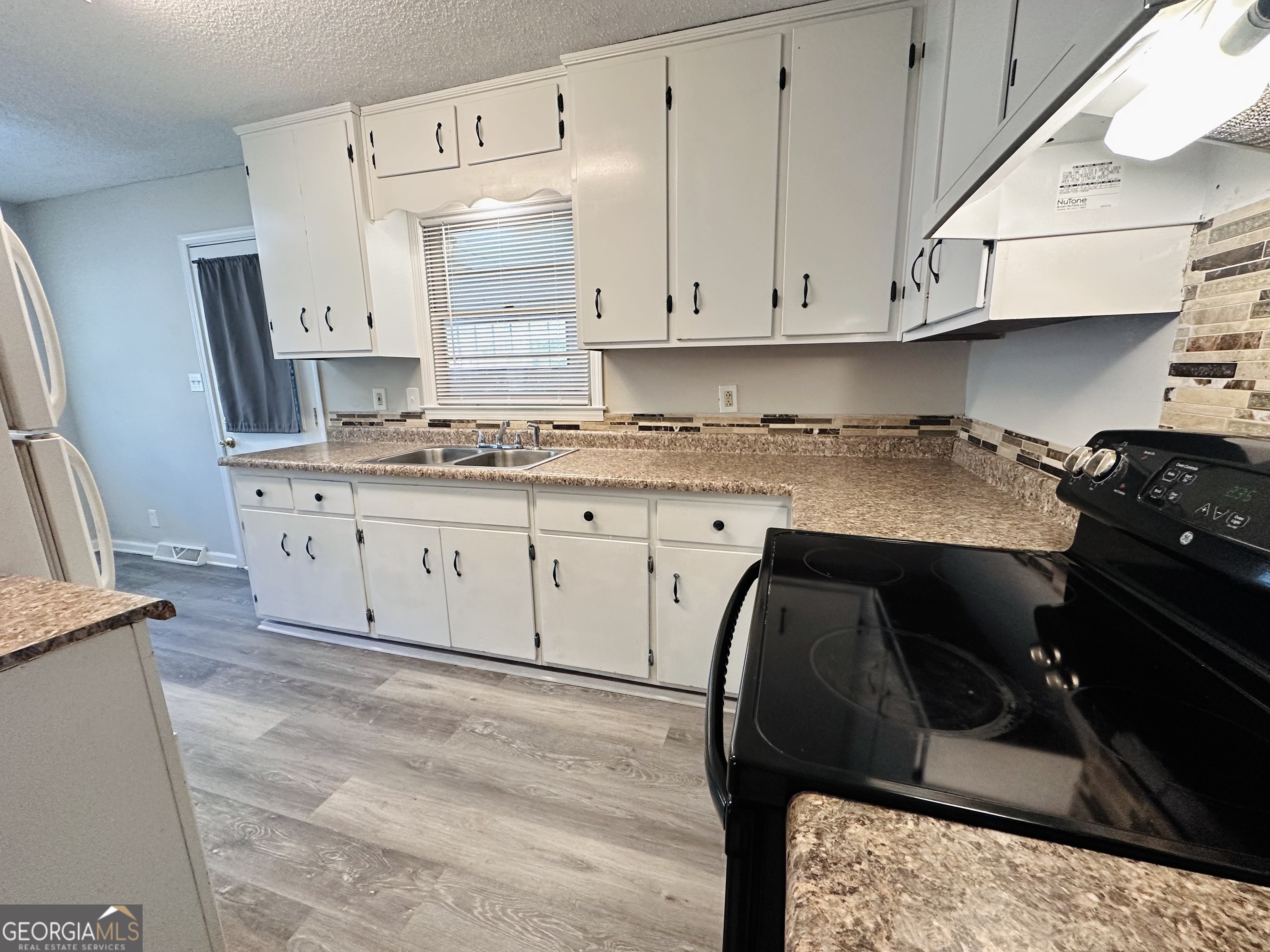514 South Broad Street Toccoa, GA 30577 - Photo 7 of 22 a kitchen with a sink dishwasher and cabinets