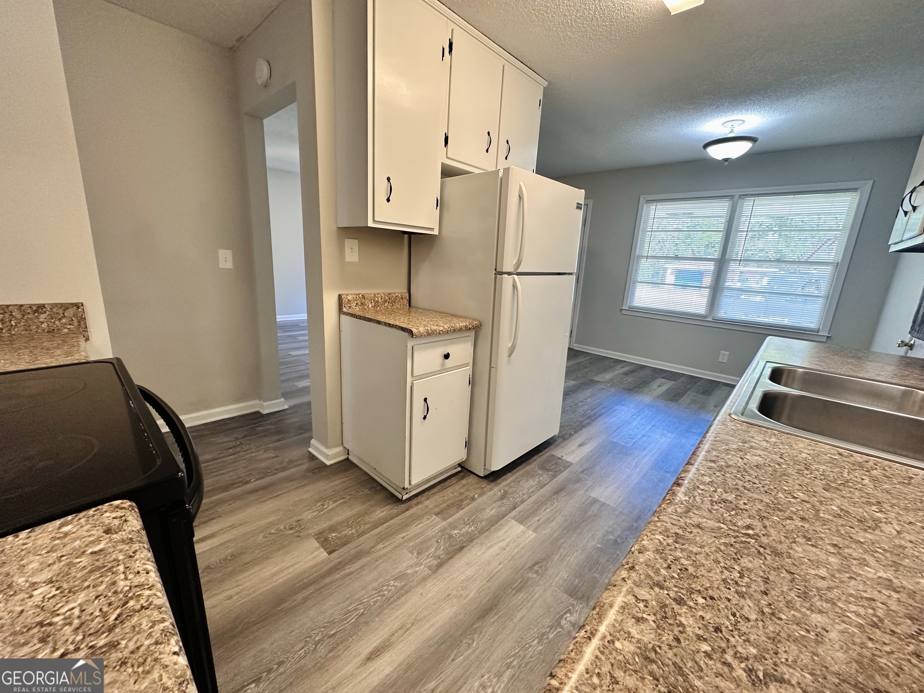 514 South Broad Street Toccoa, GA 30577 - Photo 8 of 22 a kitchen with a refrigerator a stove a wooden floor and a sink