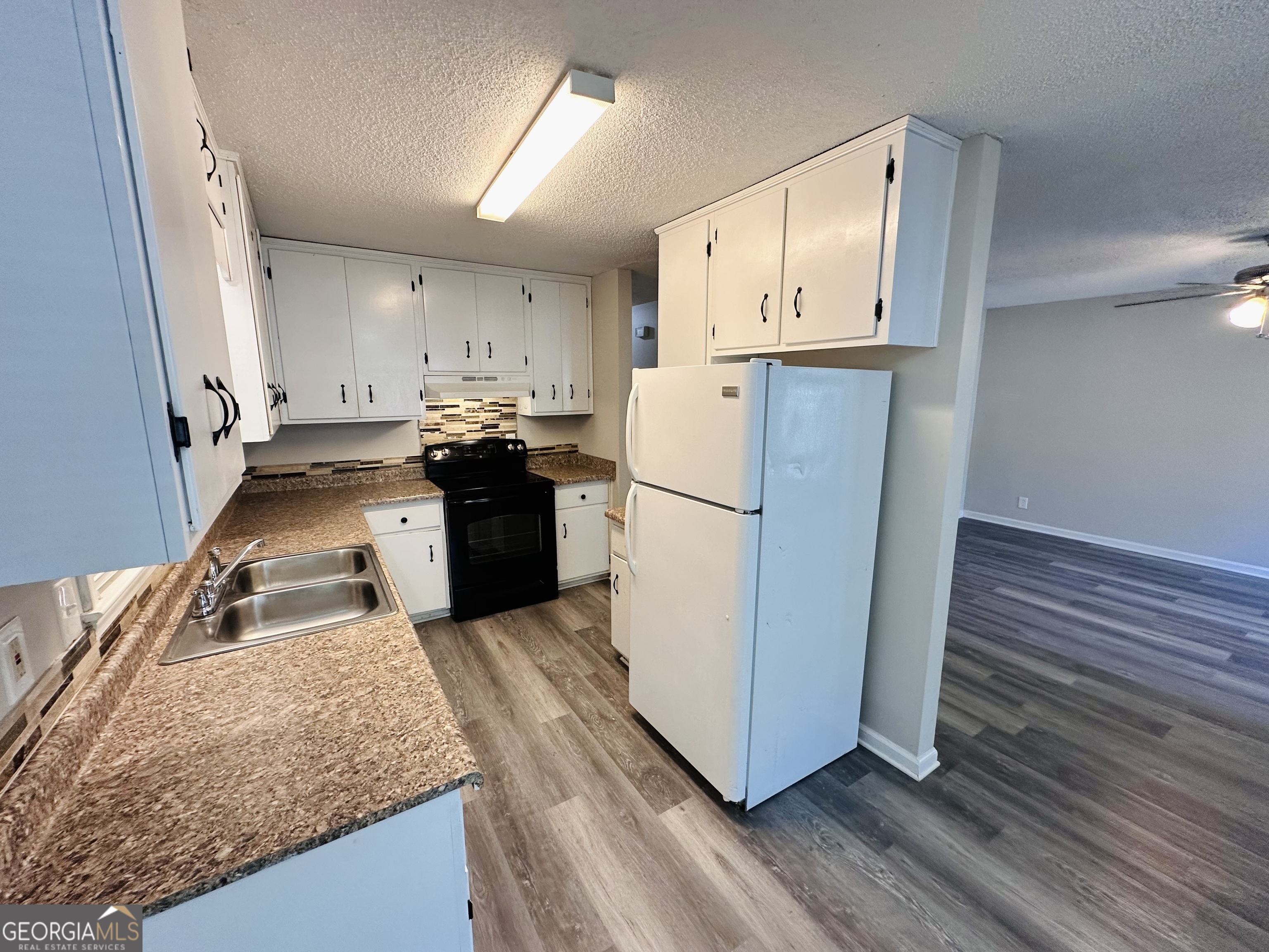 514 South Broad Street Toccoa, GA 30577 - Photo 9 of 22 a kitchen with refrigerator and white cabinets
