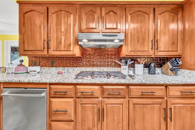 a kitchen with granite countertop a sink a stove and cabinets
