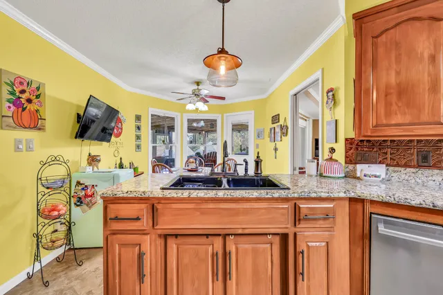 a dining hall with granite countertop a sink and a chandelier