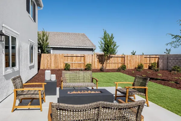 a view of a house with backyard and sitting area