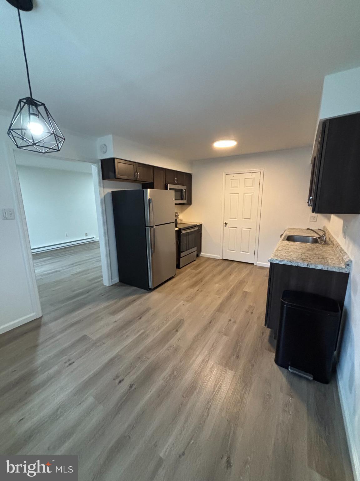 612 North Shady Retreat Road, Unit 55 Doylestown, PA 18901 - Photo 4 of 23 a kitchen with stainless steel appliances a refrigerator and a wooden floor
