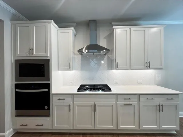 a kitchen with white cabinets and black appliances