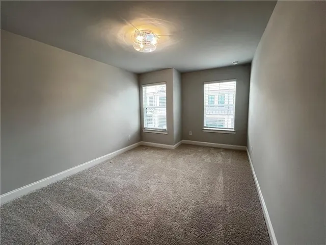 an empty room with a fireplace and windows