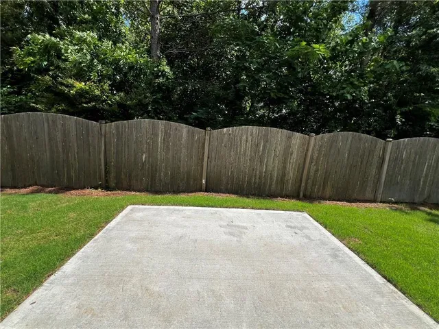 a view of a backyard with wooden fence