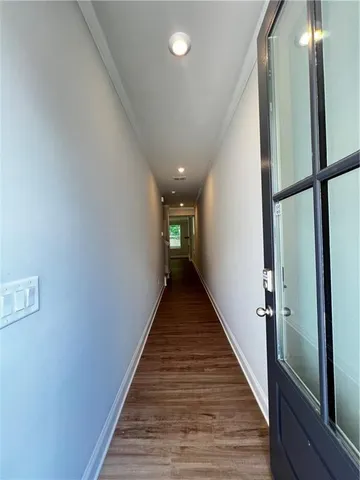 a view of a hallway with wooden floor and staircase