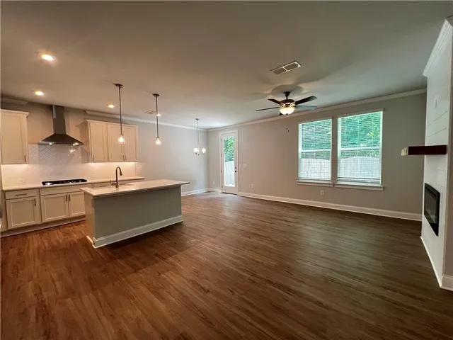 a large kitchen with stainless steel appliances a large counter top a sink a refrigerator and a window