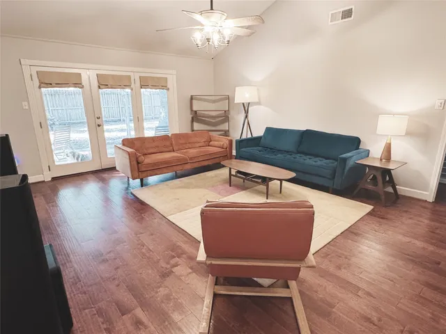 a living room with furniture and wooden floor