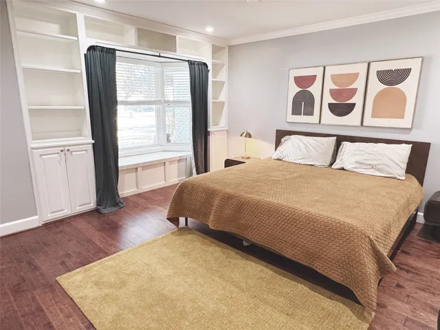 a large bed sitting in a bedroom next to a window