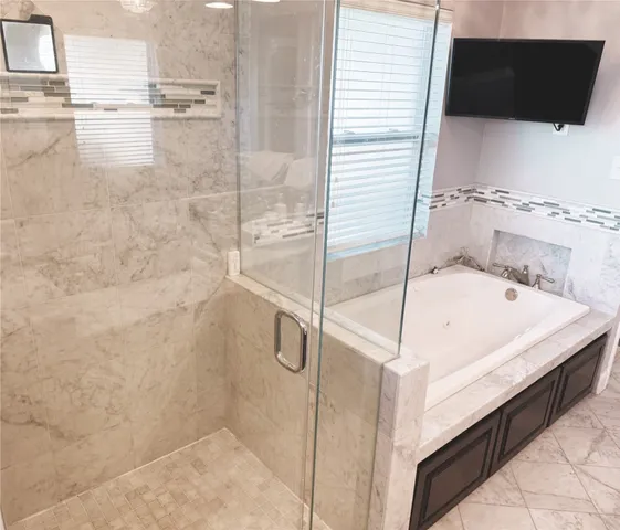 a bathroom with a bathtub and shower