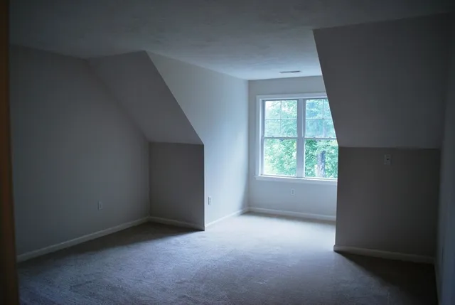 a view of a hallway with wooden floor and a livingroom