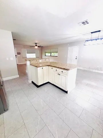 a kitchen with granite countertop white cabinets and white appliances