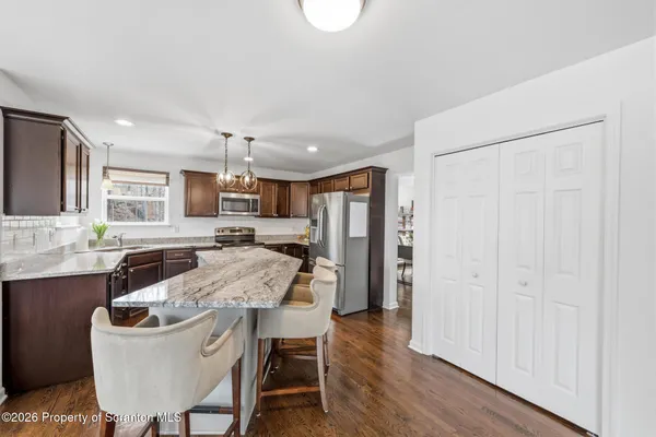a kitchen with granite countertop stainless steel appliances a sink stove and refrigerator