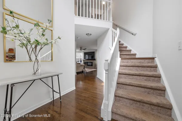 a view of staircase with lots of frames on wall and wooden floor