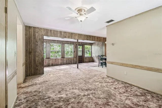 a view of a big room with wooden floor and windows